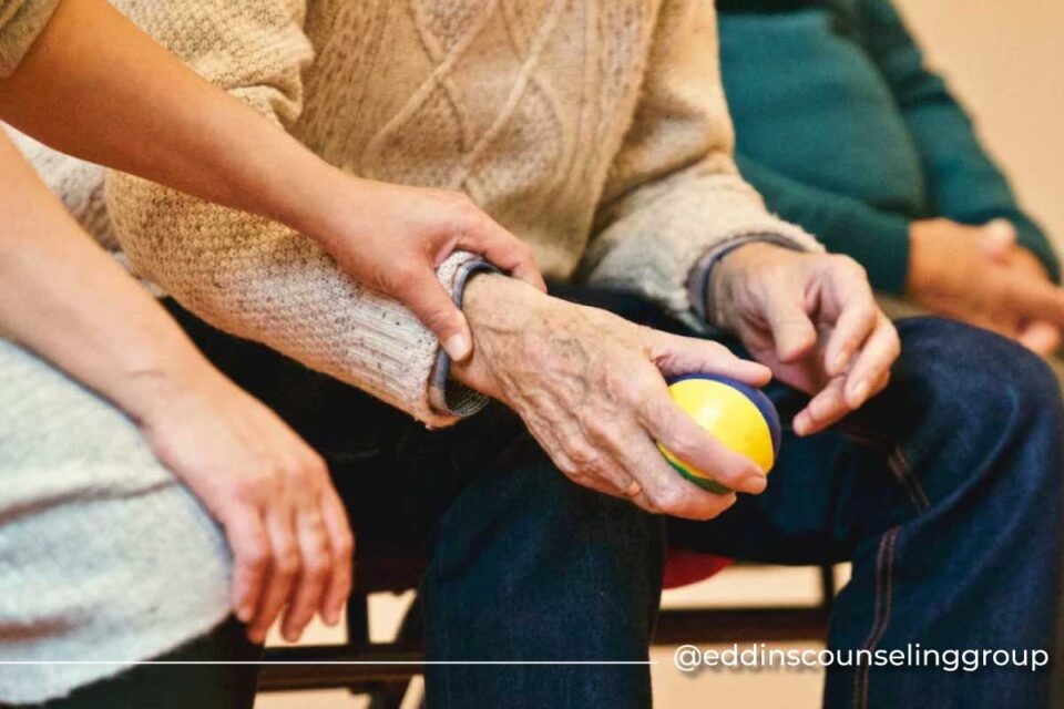 elderly man squeezing ball with care provider