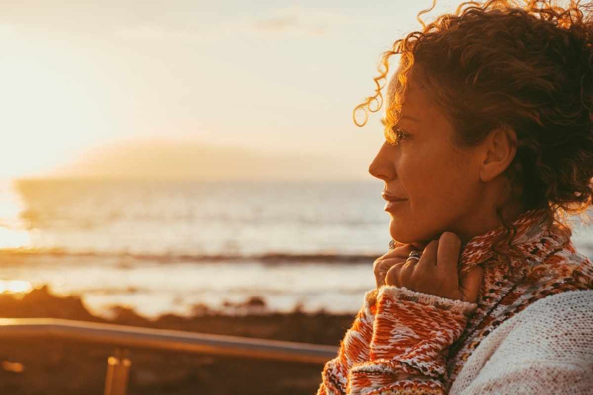 white woman standing on beach with anxiety