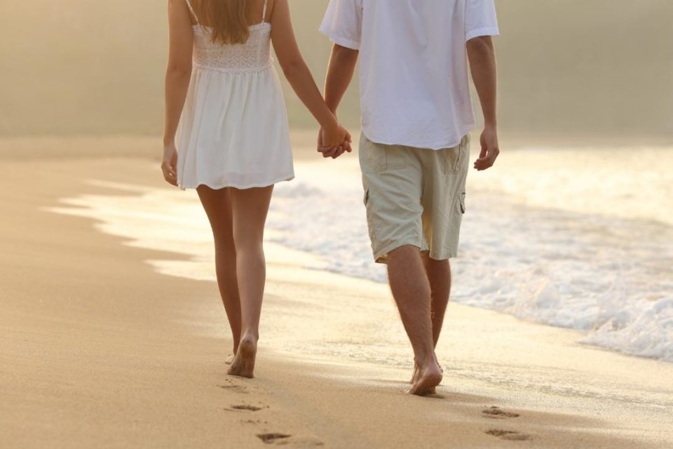 healthy relationship couple walking on beach holding hands