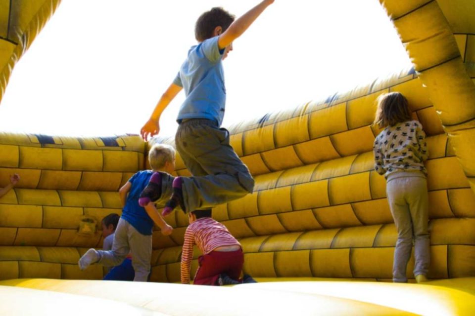 Children jumping in a bounce house on a sunny day