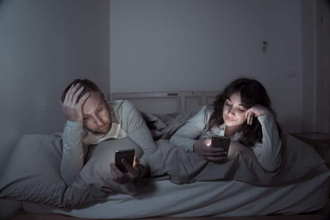 couple on their phones, not talking to each other