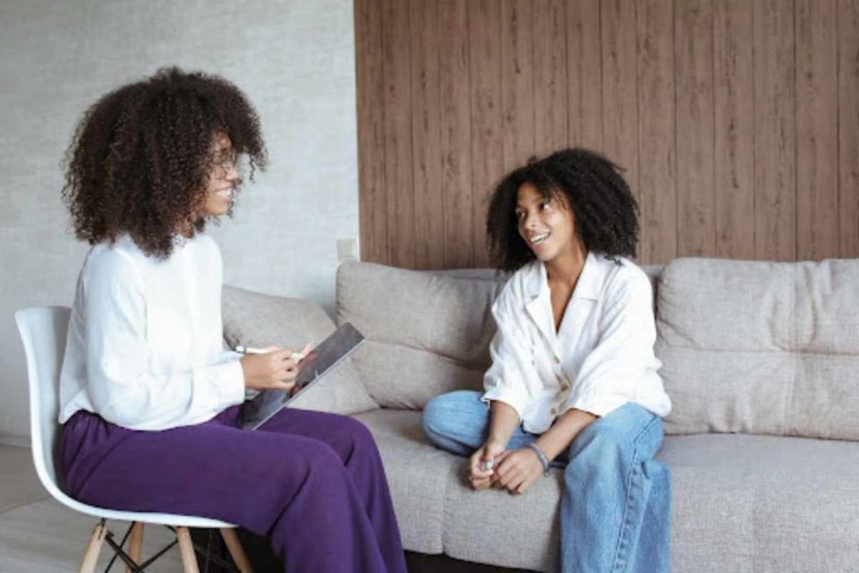 biracial woman sitting on couch talking to her therapist about anxiety how to get rid of anxiety