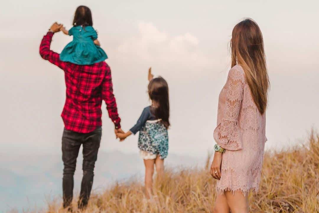 unhappy wife overlooking husband and kids