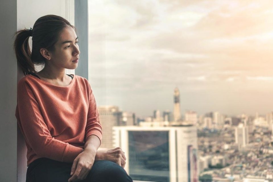 Complex PTSD asian woman looking sad out window