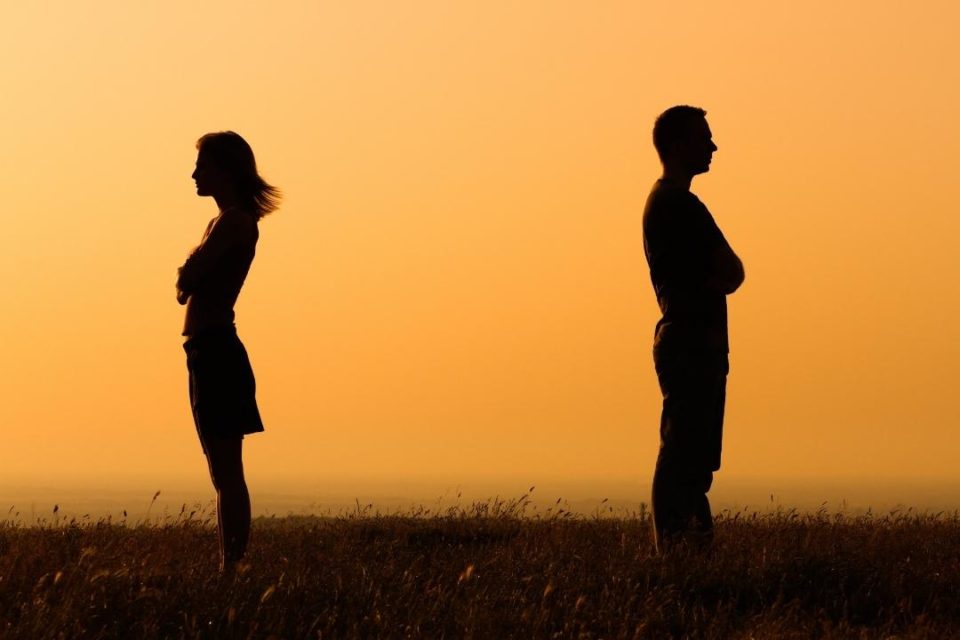 How Avoiding Conflict Can Become a Real Relationship Problem couple standing back to back after arguing