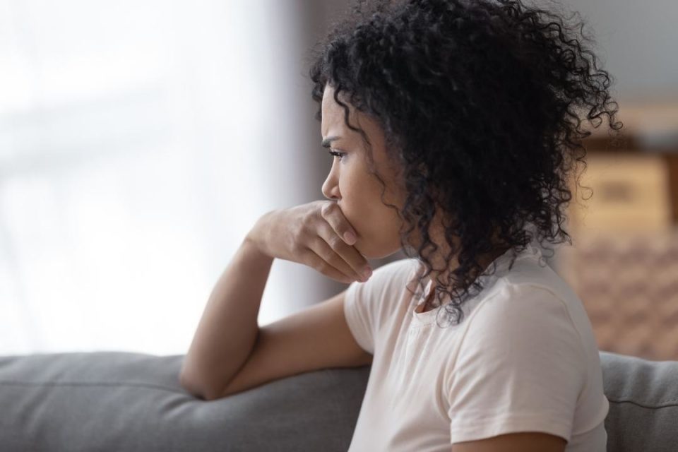 young mixed race female on couch thinking letting go of the past