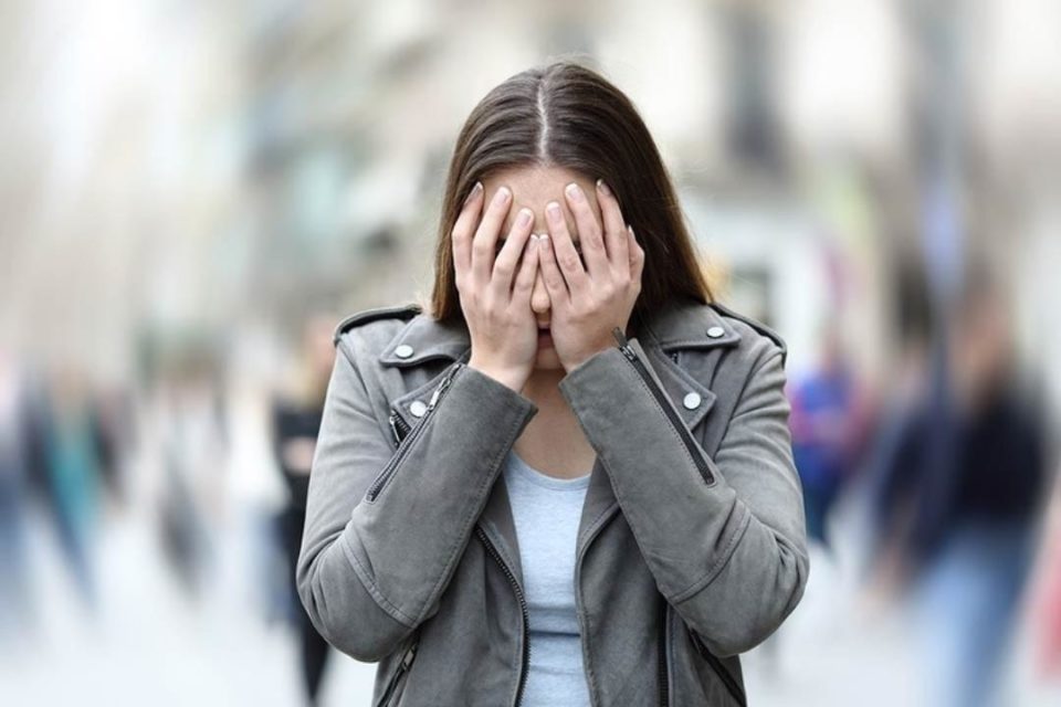 Social Anxiety Disorder Causes: 5 Reasons Why You Feel Fearful Around People white woman holding head in her hands