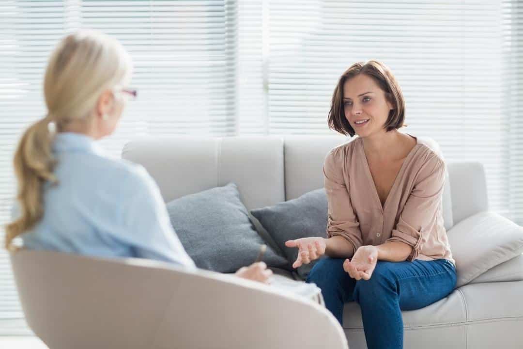 core beliefs white woman sitting on couch talking to therapist