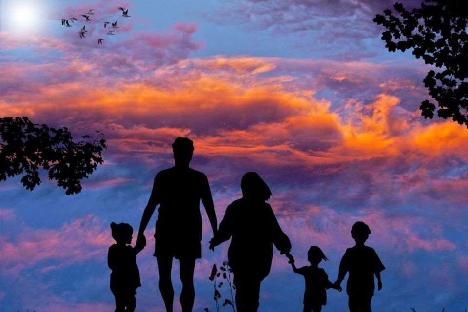 happy family holding hands at sunset
