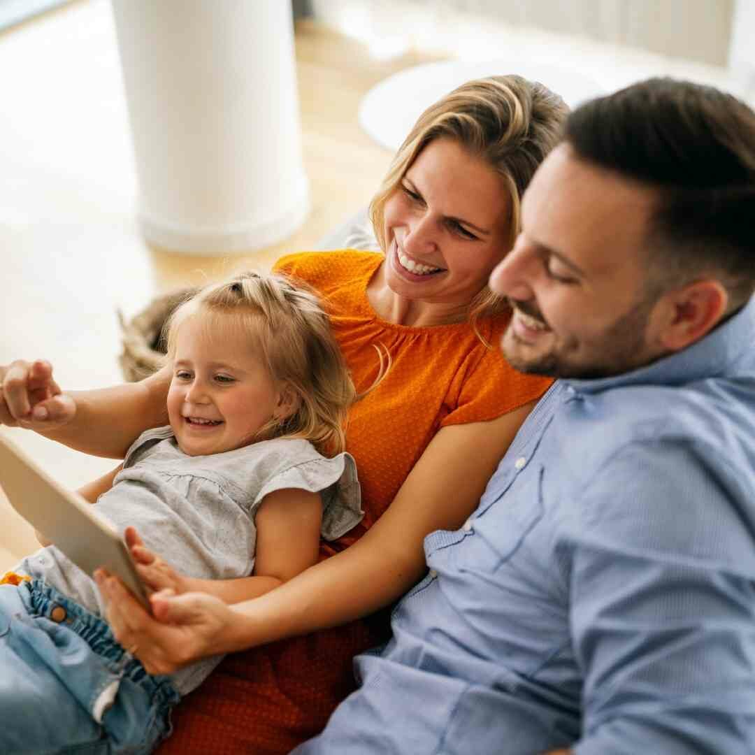 mom dad and daughter lying on couch reading book resilient parenting support group