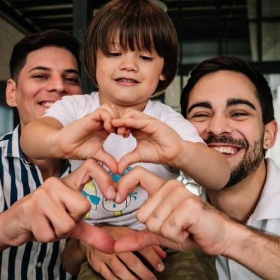 gay couple with child making heart after gay couples therapy
