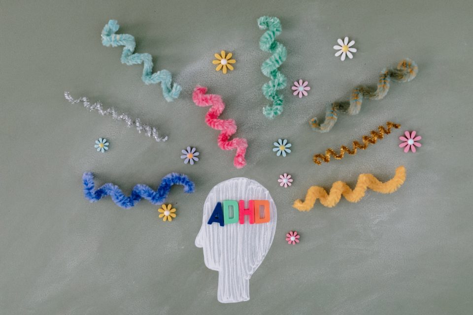 A white human head with colorful craft squiggles surrounding it representing adult adhd
